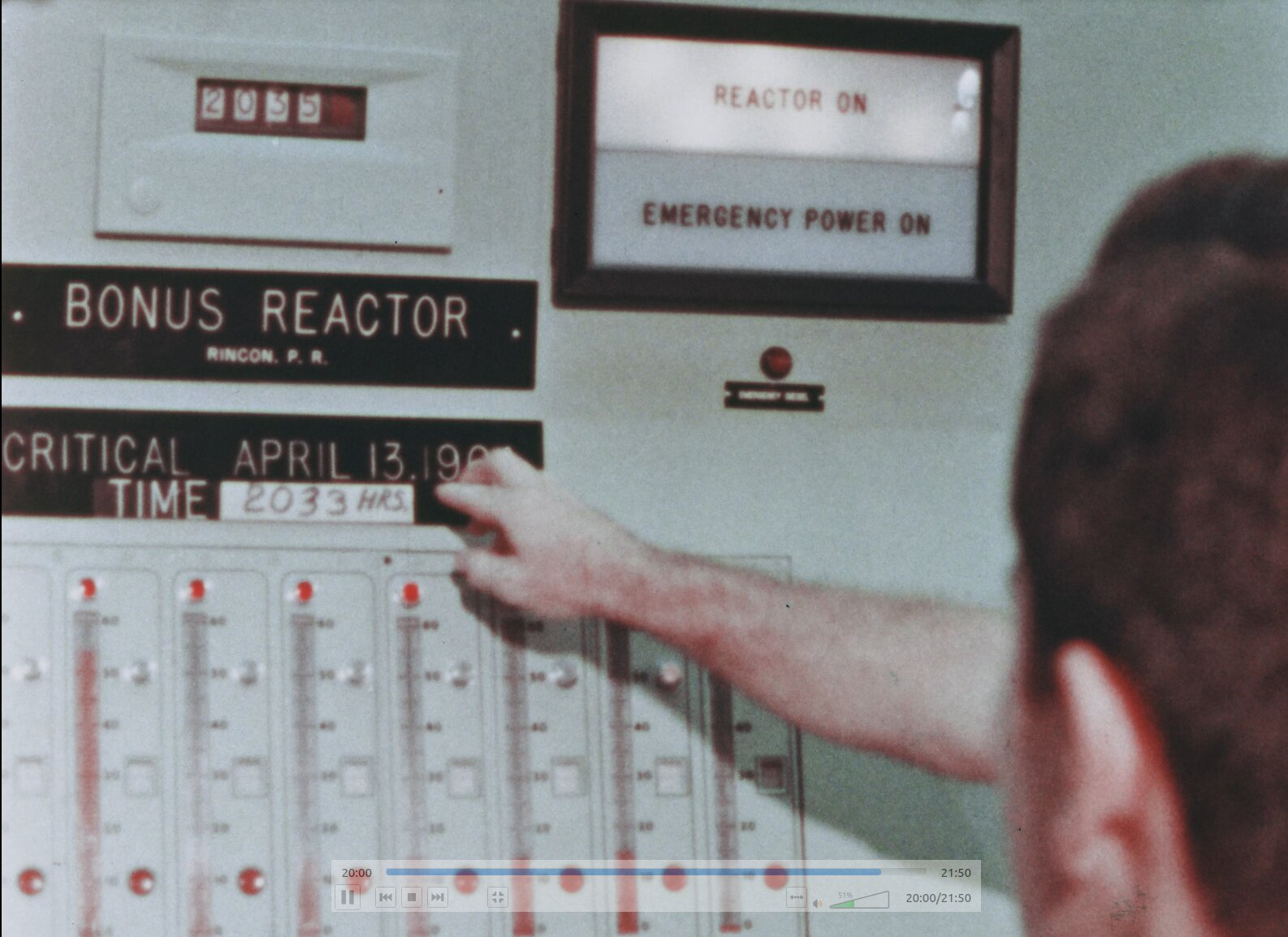 Control room view showing placard about BONUS going critical on April 13, 1964 at 2033 hours. the REACTOR ON sign is lit.