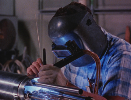 Worker at CANEL welding an in-reactor lithium coolant test loop to be inserted into the Engineering Test Reactor in Idaho